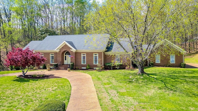 view of front of home with brick siding, crawl space, and a front lawn