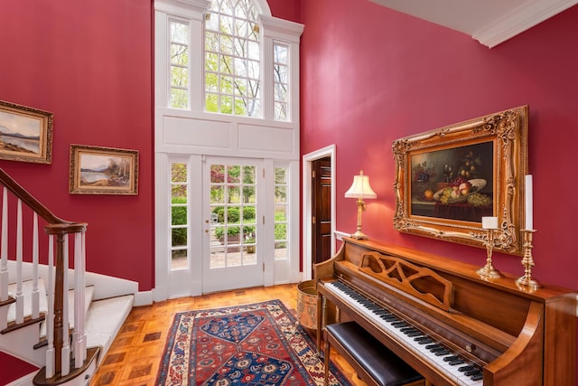 foyer featuring a high ceiling, baseboards, and stairway