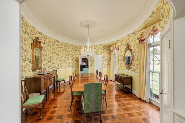 dining area featuring a chandelier, crown molding, wallpapered walls, and wainscoting
