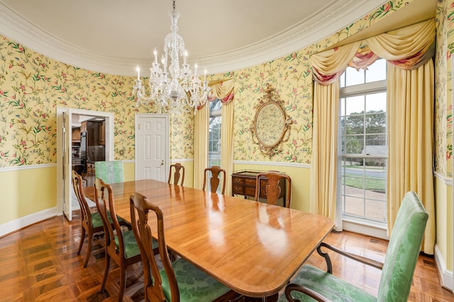 dining room with ornamental molding, a chandelier, wainscoting, and wallpapered walls