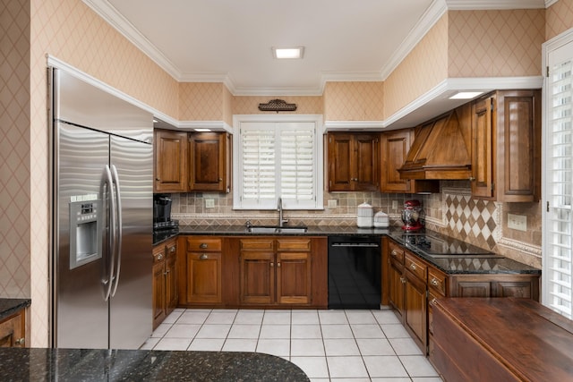 kitchen featuring crown molding, black appliances, a sink, wallpapered walls, and custom range hood