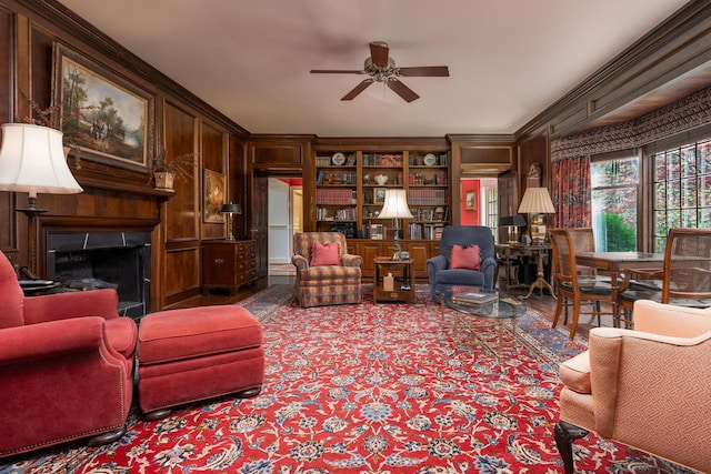 carpeted living room with a fireplace, a ceiling fan, and crown molding