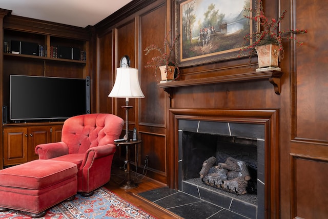 living area with a fireplace with flush hearth and wood finished floors