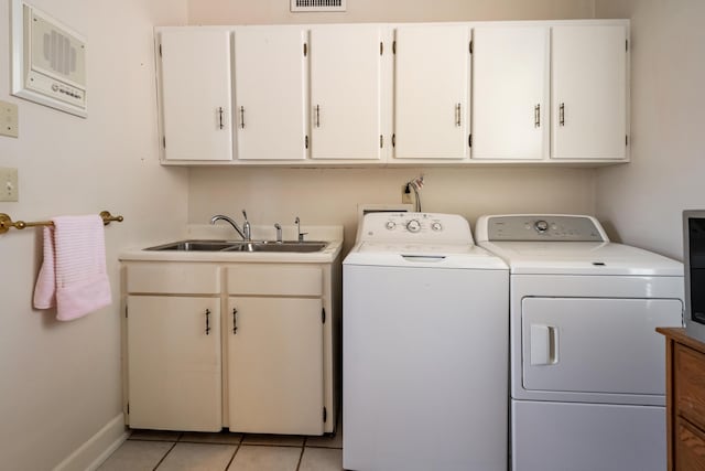 laundry room with visible vents, baseboards, separate washer and dryer, a sink, and cabinet space
