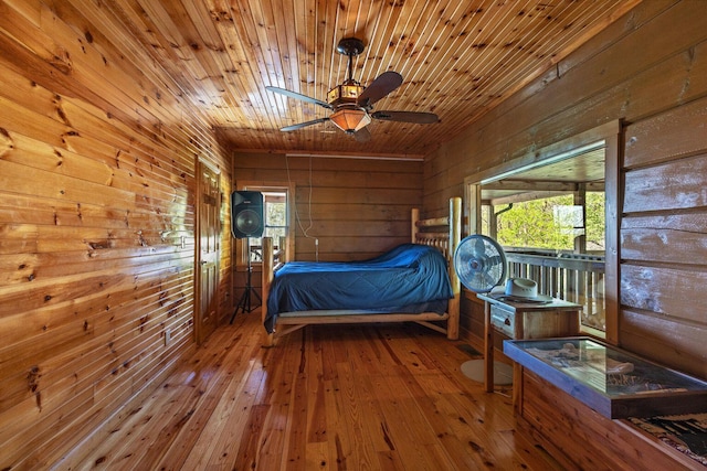 bedroom with wooden walls, hardwood / wood-style flooring, and wood ceiling