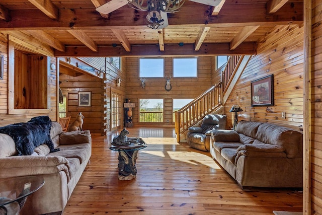 living room with wood ceiling, wood walls, hardwood / wood-style floors, and stairway