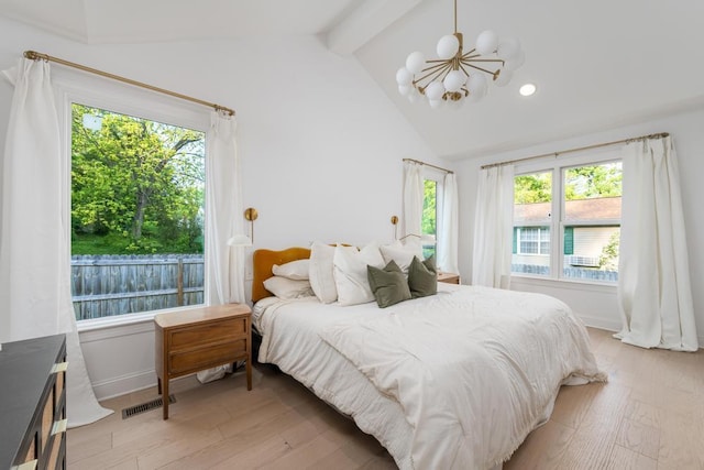 bedroom with lofted ceiling with beams, an inviting chandelier, multiple windows, and light wood finished floors