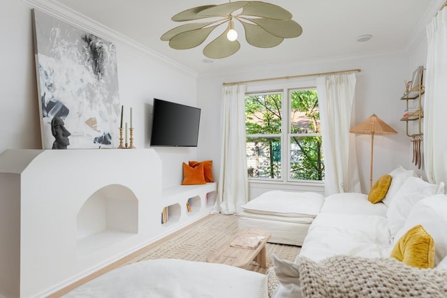 living room featuring a ceiling fan, wood finished floors, and ornamental molding
