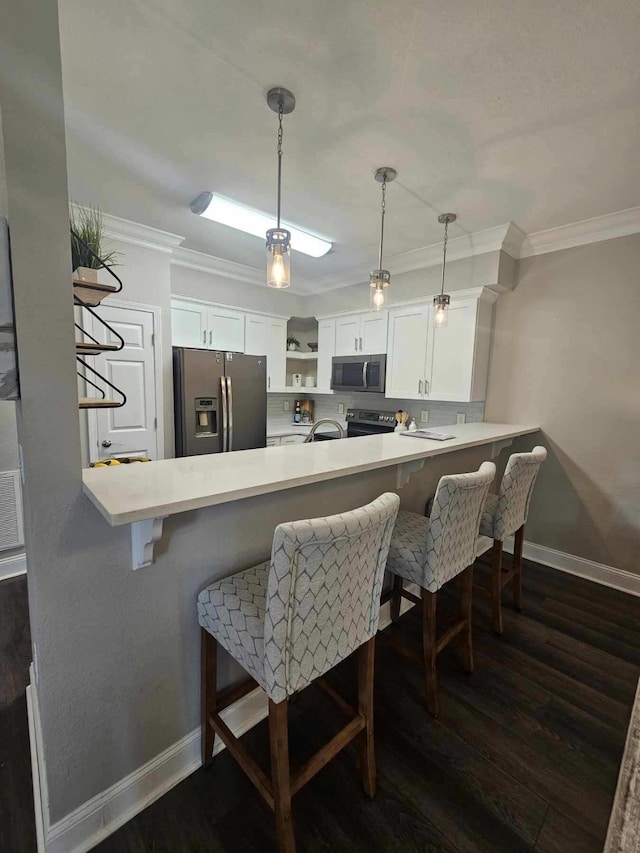 7845 Legacy Park Ct, Chattanooga, TN 37421 - kitchen featuring appliances with stainless steel finishes, crown molding, dark wood-style flooring, a peninsula, and white cabinetry