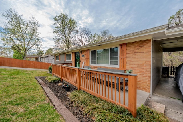 3745 Premium Dr, Chattanooga, TN 37415 - view of front of house with brick siding, a front yard, a wooden deck, and fence