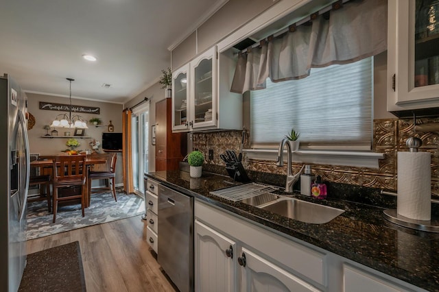 3745 Premium Dr, Chattanooga, TN 37415 - kitchen with stainless steel appliances, dark stone countertops, wood finished floors, a sink, and decorative backsplash