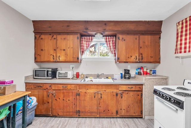 3300 Redding Rd, Chattanooga, TN 37415 - kitchen with light countertops, a sink, stainless steel microwave, white electric range oven, and light wood-style flooring