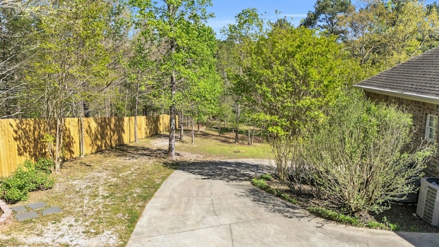 view of yard featuring central air condition unit and fence