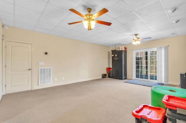 recreation room featuring visible vents, baseboards, a ceiling fan, a drop ceiling, and carpet flooring