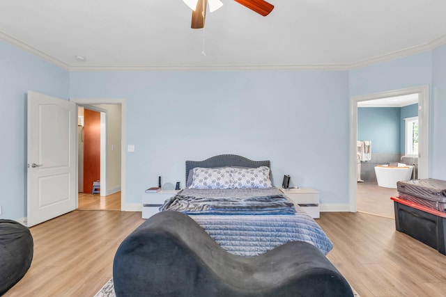 bedroom with baseboards, ornamental molding, ensuite bathroom, a ceiling fan, and wood finished floors