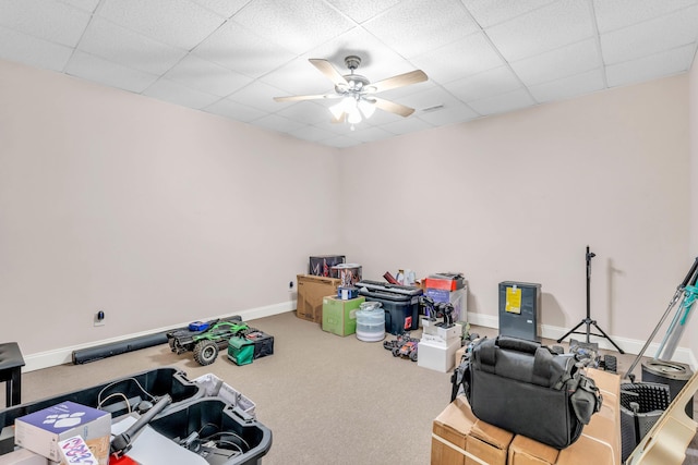 misc room featuring a drop ceiling, baseboards, a ceiling fan, and carpet