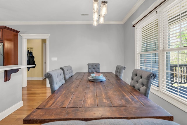 dining space featuring ornamental molding, visible vents, light wood-style flooring, and baseboards