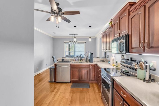kitchen with light wood-type flooring, ornamental molding, stainless steel appliances, ceiling fan with notable chandelier, and a sink