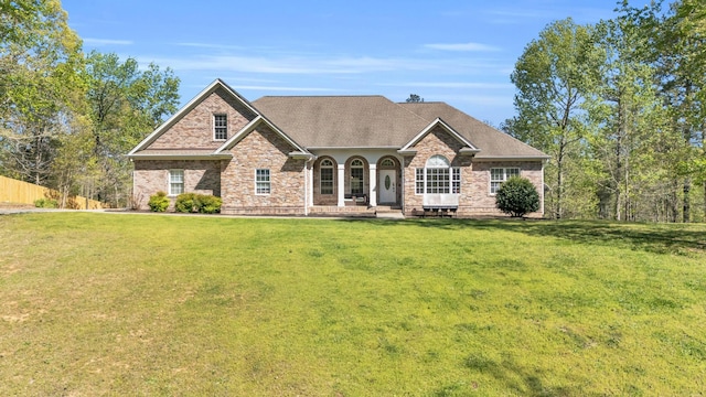 view of front of property with a shingled roof and a front yard
