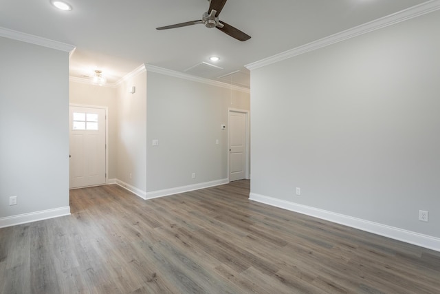 unfurnished room with ornamental molding, attic access, baseboards, and a ceiling fan