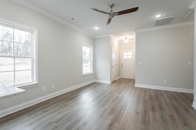 spare room featuring visible vents, ceiling fan, wood finished floors, and baseboards