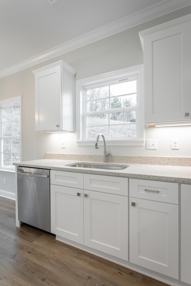 kitchen featuring stainless steel dishwasher, white cabinets, a sink, and crown molding