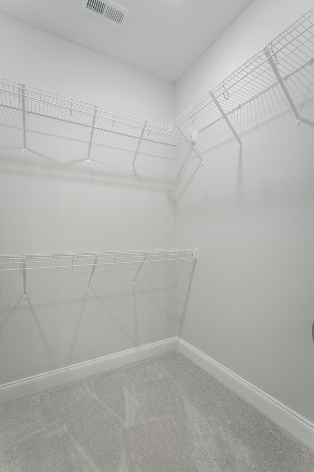 walk in closet featuring visible vents and carpet flooring