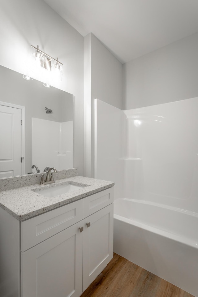 full bathroom with wood finished floors, vanity, and bathtub / shower combination