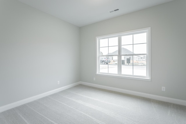 carpeted spare room with baseboards and visible vents