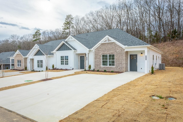 view of front of home featuring roof with shingles, board and batten siding, and central AC unit