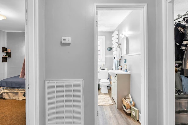 bathroom with wood finished floors, visible vents, toilet, and vanity