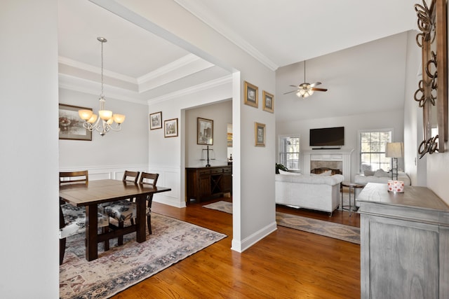 12237 Wildlife Pl, Soddy Daisy, TN 37379 - dining room featuring crown molding, wood finished floors, ceiling fan with notable chandelier, a wainscoted wall, and a fireplace
