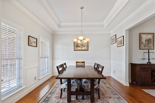12237 Wildlife Pl, Soddy Daisy, TN 37379 - dining area with a raised ceiling, wood finished floors, a notable chandelier, and wainscoting