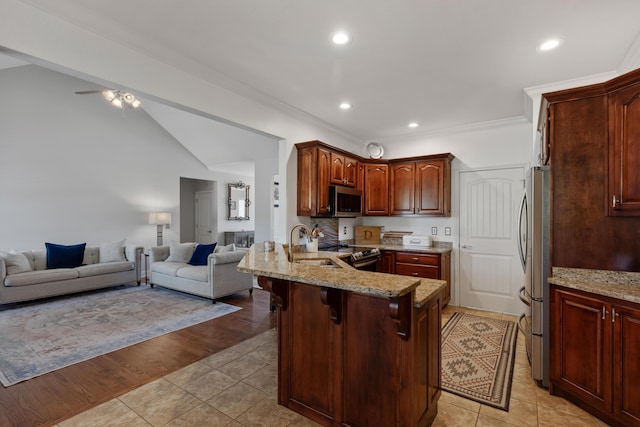 12237 Wildlife Pl, Soddy Daisy, TN 37379 - kitchen with a sink, open floor plan, stainless steel appliances, a peninsula, and light stone countertops