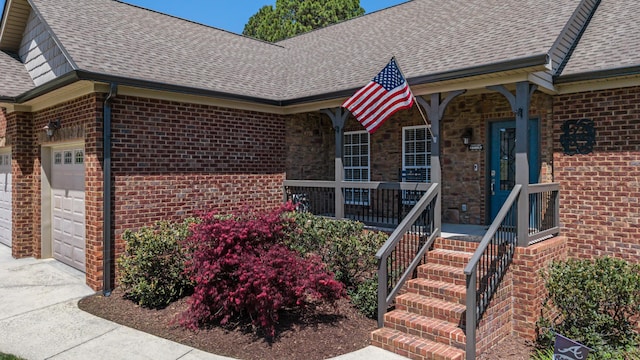 12237 Wildlife Pl, Soddy Daisy, TN 37379 - entrance to property with driveway, a porch, a garage, brick siding, and roof with shingles