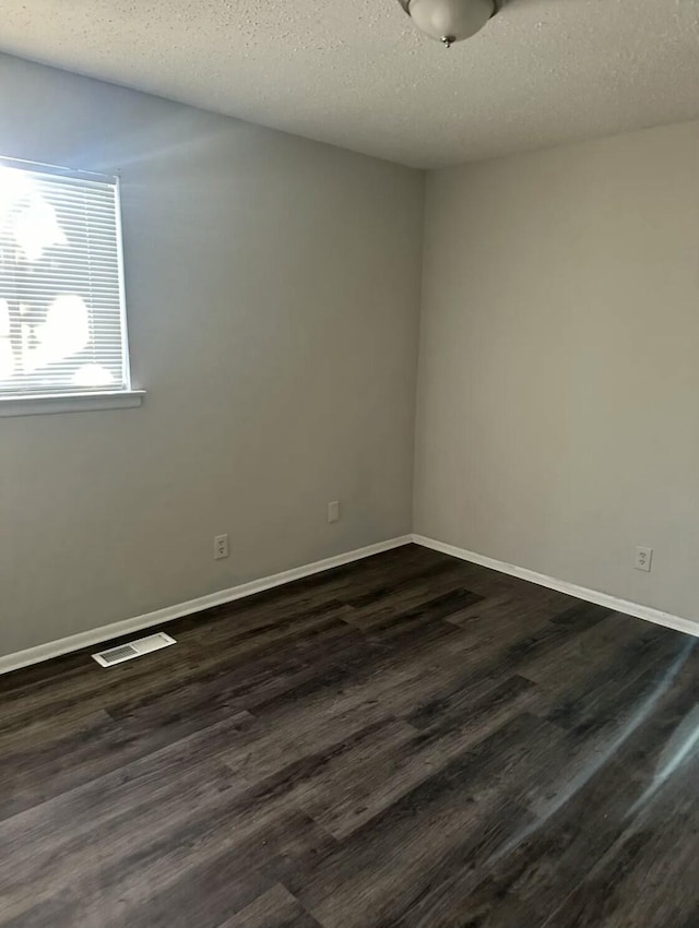 810 Forest Dale Ln, Hixson, TN 37343 - unfurnished room featuring dark wood finished floors, baseboards, visible vents, and a textured ceiling