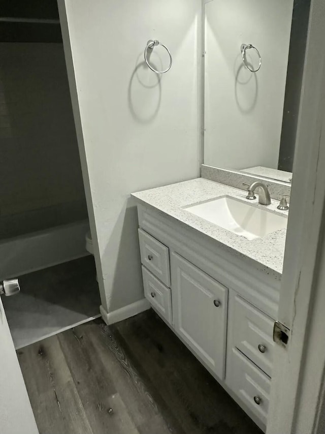 810 Forest Dale Ln, Hixson, TN 37343 - bathroom featuring wood finished floors, toilet, vanity, a bath, and baseboards