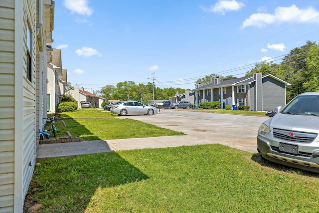 exterior space featuring concrete driveway and a residential view