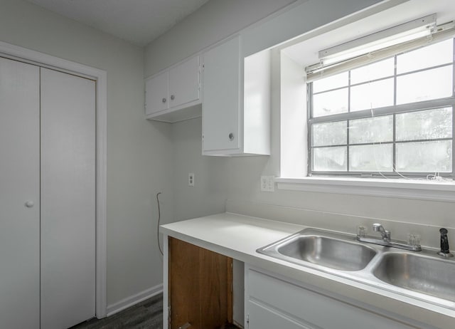 kitchen featuring white cabinetry, a sink, dark wood-style floors, and light countertops
