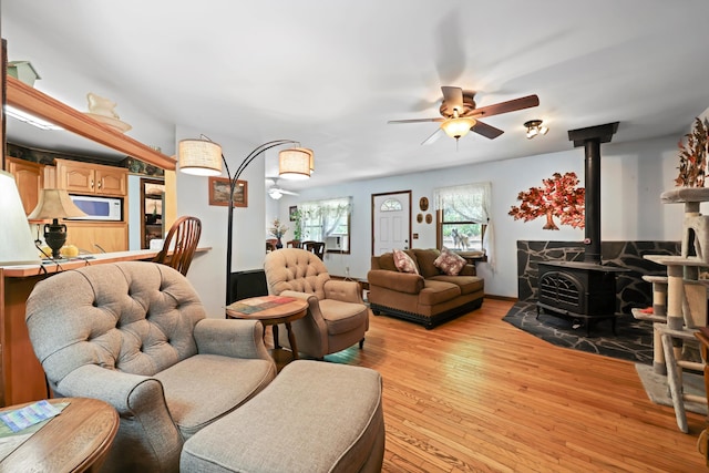 798 Deerfield Ln, Sugar Valley, GA 30746 - living room with a ceiling fan, a wood stove, and light wood-style flooring