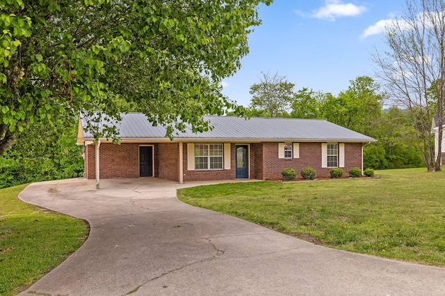 ranch-style house with concrete driveway, a front yard, brick siding, and metal roof