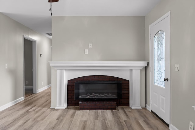 room details featuring wood finished floors, baseboards, visible vents, and a brick fireplace