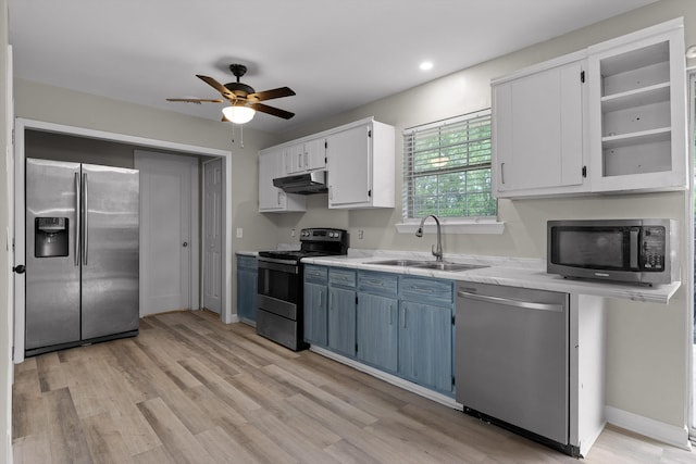 kitchen featuring light wood-style floors, under cabinet range hood, appliances with stainless steel finishes, a sink, and a ceiling fan
