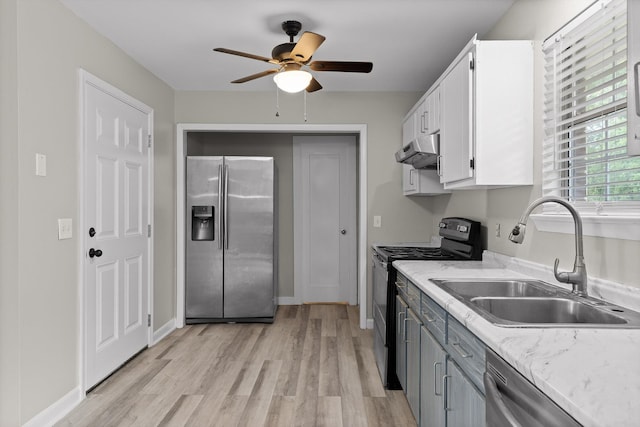 kitchen featuring a sink, stainless steel appliances, light wood finished floors, and under cabinet range hood