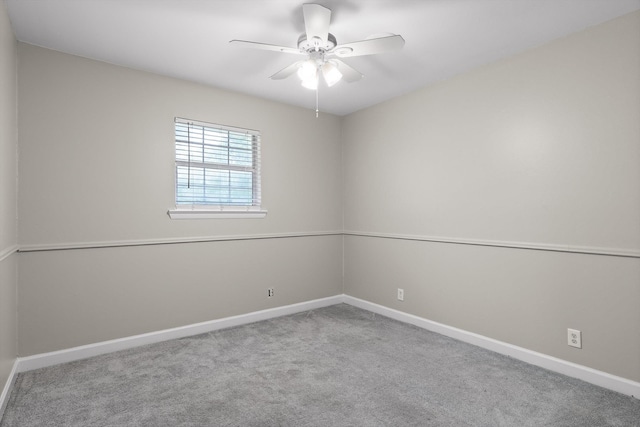 carpeted empty room with a ceiling fan and baseboards