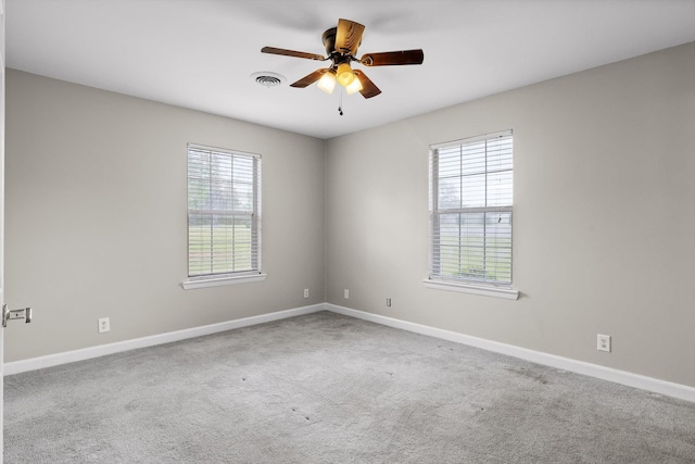 spare room with visible vents, a ceiling fan, carpet flooring, and baseboards