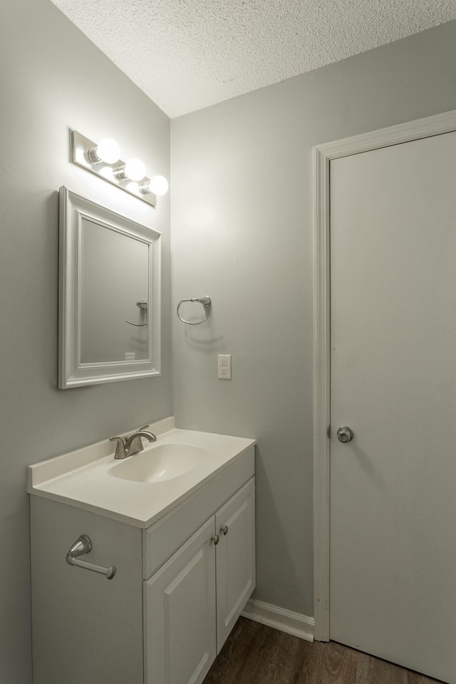bathroom featuring wood finished floors, a textured ceiling, and vanity
