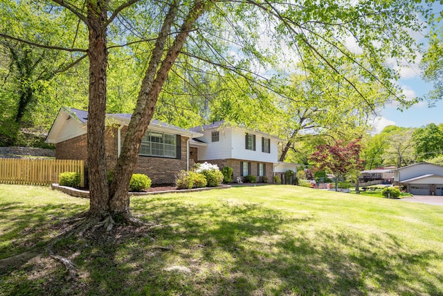 4802 Woodland Cir, Hixson, TN 37343 - tri-level home with fence, a front lawn, brick siding, and a detached garage