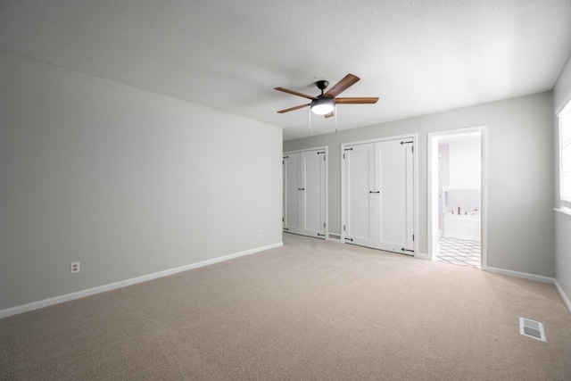 4802 Woodland Cir, Hixson, TN 37343 - unfurnished bedroom featuring visible vents, ensuite bath, baseboards, two closets, and light colored carpet
