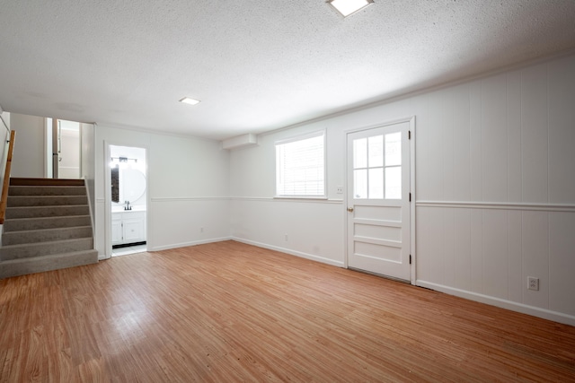 4802 Woodland Cir, Hixson, TN 37343 - unfurnished living room with stairway, a sink, light wood-style floors, baseboards, and a textured ceiling